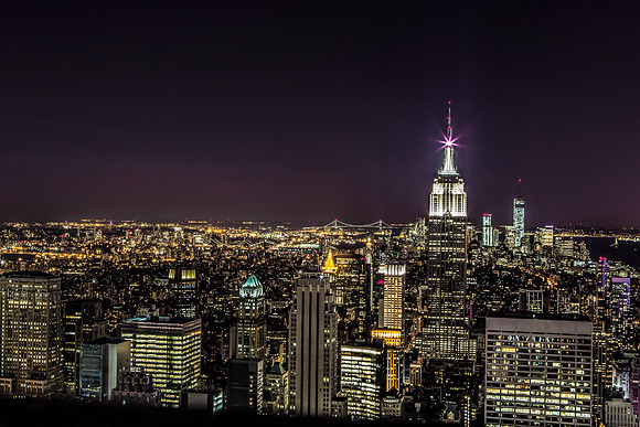 View of New York City at night from above.  Empire State Building is lit up.  New York City, NY